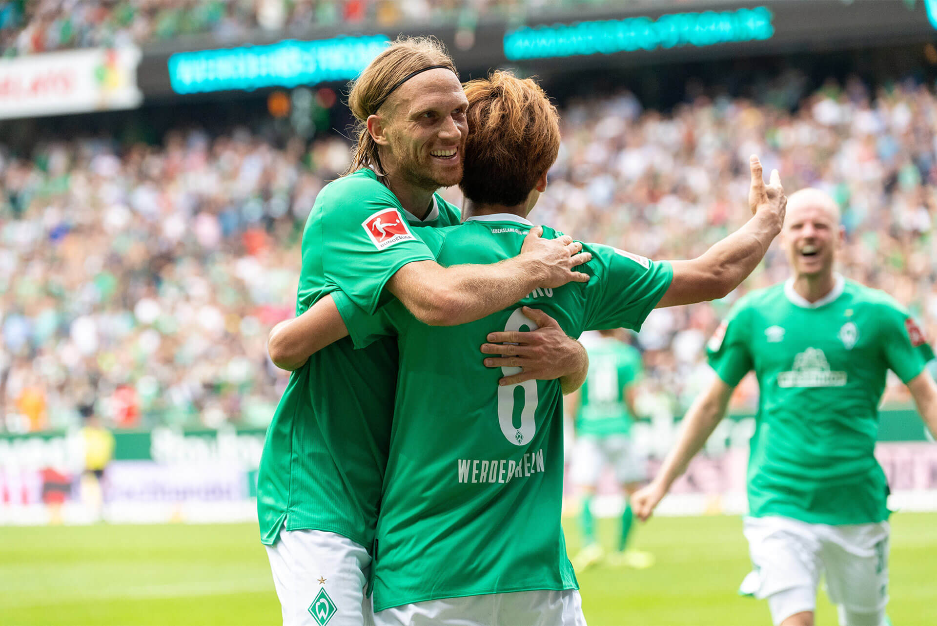 Werder Bremen Spieler feiern mit den Fans nach einem wichtigen Sieg.